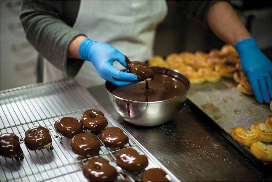 Obrador bañando dulces en chocolate